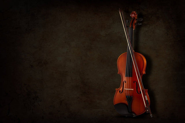 Violin and bow against a dark textured background